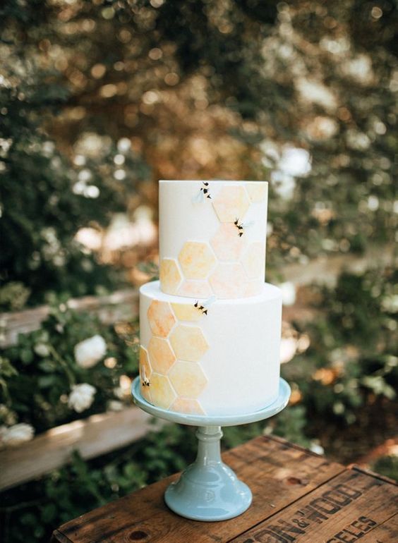 a neutral wedding cake with orange and yellow honeycombs and some black touches is a lovely idea for the summer