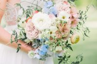 a pastel wedding bouquet of white, blush and serenity blue blooms and greenery and some cascading touches