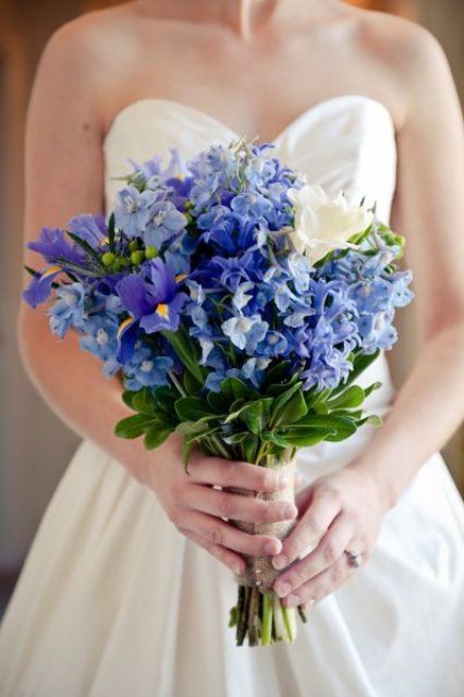 a pretty wedding bouquet done in blue and white, with irises plus a burlap wrap is a lovely idea for a rustic wedding