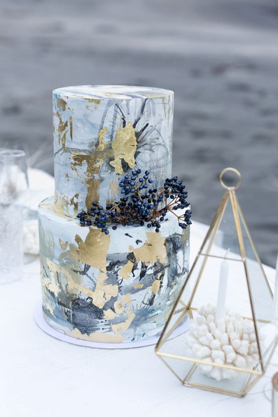 a quirky grey watercolor wedding cake with gold leaf and privet berries is cool for winter