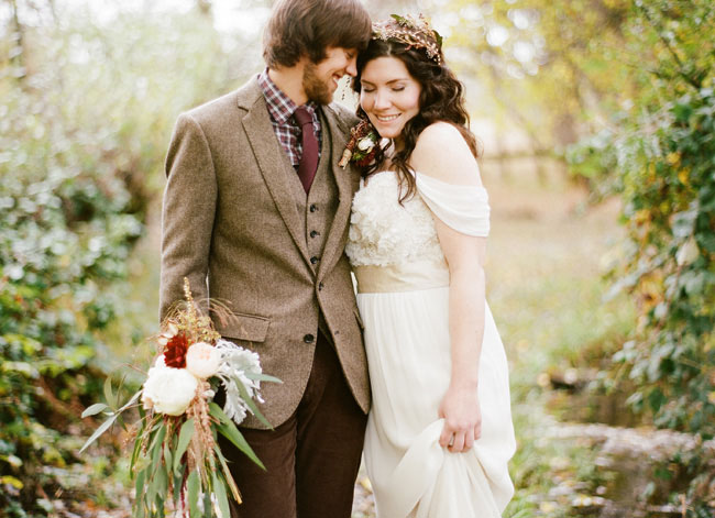 a relaxed groom's outfit with brown pants, a tan tweed blazer and waistcoat, a checked button down, a burgundy tie