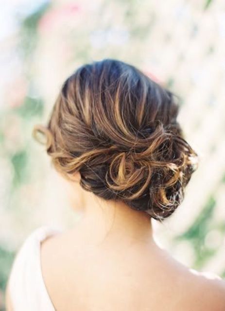 a romantic low side swept updo with curls and a bump is a chic idea for a bride with medium length hair