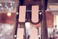 a rustic wedding seating chart of a vintage ladder, horseshoes and cards is a cute DIY idea