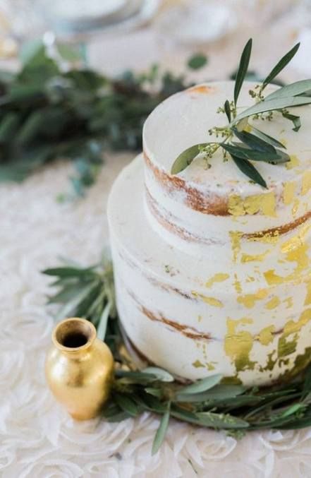 a simple and stylish naked wedding cake with gold leaf and some fresh greenery is a chic and genius idea