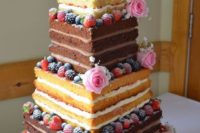 a square naked wedding cake with a Beetle car and a VW camper on top plus fresh berries and blooms