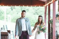 a stylish groom’s outfit with a light blue blazer, a white button down, burgundy pants, brown shoes
