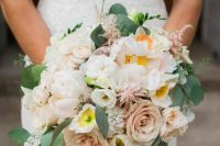 a subtle wedding bouquet of blush roses, white freesias, greenery and lisianthus is a lovely idea for a delicate spring or summer wedding