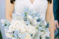 a subtle wedding bouquet of white roses, serenity blue blooms, pale foliage and thistles is a chic and stylish idea