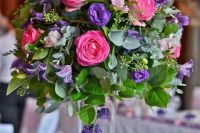 a super bold wedding centerpiece of pink roses, purple freesias, greenery is a fantastic idea for a colorful wedding