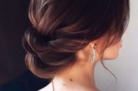 a super elegant low twisted updo with a bump and some locks down is a gorgeous idea for a refined bride