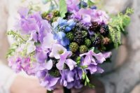 a unique wedding bouquet of lilac and blue freesia, greenery and berries is a cool solution for spring or summer