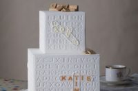 a whimsy white square wedding cake inspired by scrabble games is a fun and quirky idea for a modern wedding