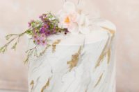 a white marble wedding cake with godl touches, blush and bold blooms plus XO toppers