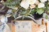 a wooden board with a map and a pebble with a monogram is a cool idea to mark each place setting