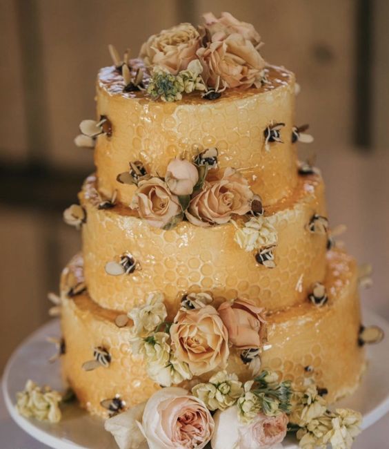 a yellow honeycomb wedding cake with pastel and neutral blooms and bees topped with honey is a lovely idea for summer