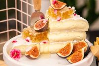 an alternative wedding cake of cheese stacked, with honeycombs and figs and bold blooms is a fantastic idea for a wedding