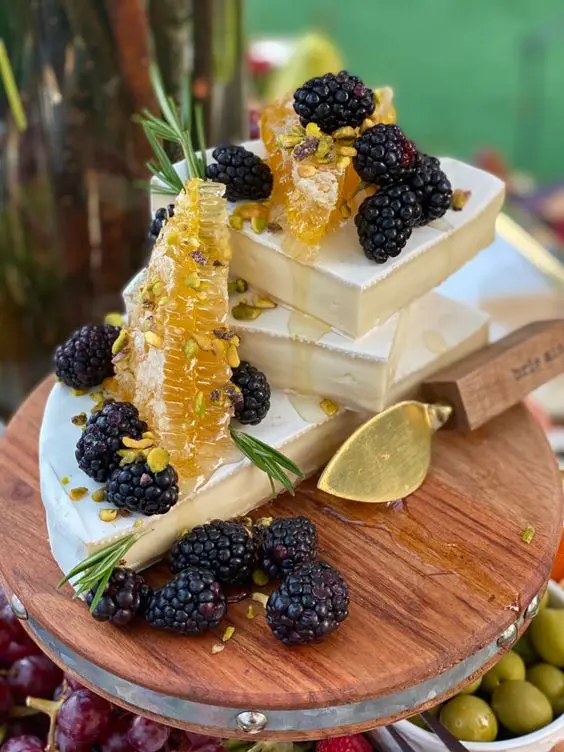 stacked cheese topped wiht pistachios, blackberries and honeycombs is a lovely idea for a wedding, instead of a real wedding cake