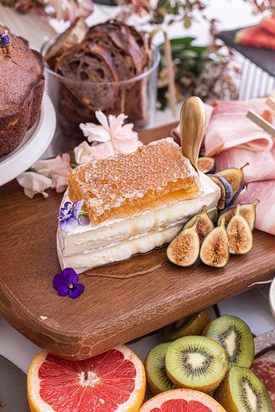 stacked cheese topped with honeycombs and figs around plus bold blooms is a great alternative to a wedding cake