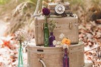 whimsy vintage travel wedding decor of stacked suitcases, bright blooms and a vintage telephone
