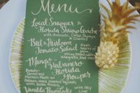 a green and gold menu plus a little gilded pineapple for a tropical bridal shower