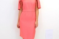 a bright pink sheath knee dress with short lace sleeves, a trendy square neckline and a whimsy hat with a birdcage veil