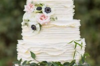 a white textural buttercream wedding cake decorated with greenery, white anemones and pink roses is a cute idea for a spring or summer wedding