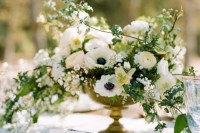 a refined wedding centerpiece of white anemones and ranunculus plus some greenery is a lovely idea for a spring or summer wedding