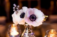 a small neutral wedding centerpiece of white anemones and some berries is a catchy and simple arrangement that you can make yourself in a minute