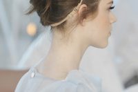 a refined French twist updo with a volume on top, a messy twisted chignon and an embellished headpiece