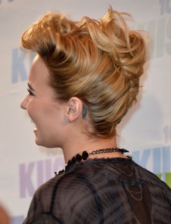a crazy and messy French twist updo with a voluminous bang fixed up and a messy chignon