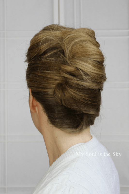 a very formal French twist updo with a large volume on top and ombre hair that makes it more spectacular