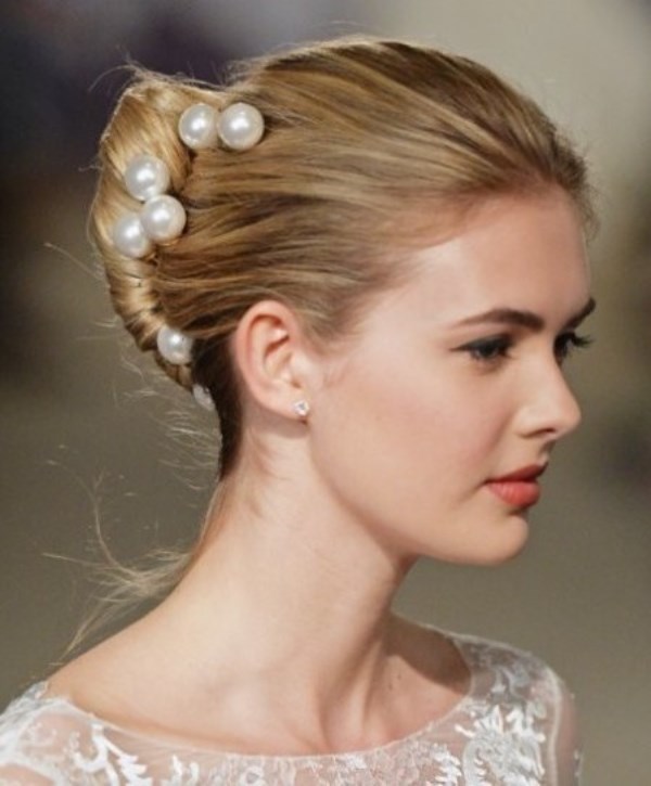 a French twisted updo with a textural top and large pearl pins that make it elegant and refined