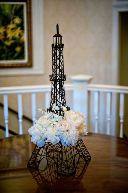 an Eiffel Tower decorated with white blooms is a cool decoration for your Parisian-themed bridal shower