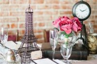 a Parisian-themed bridal shower tablescape with an Eiffel Tower, clocks and pink blooms is a beautiful idea