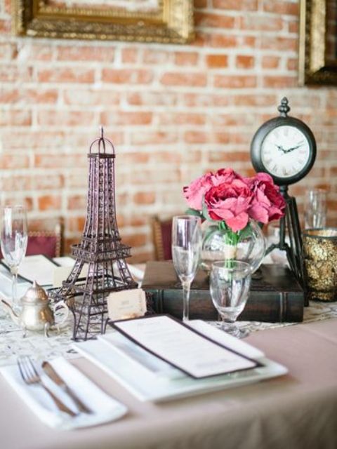 a Parisian themed bridal shower tablescape with an Eiffel Tower, clocks and pink blooms is a beautiful idea