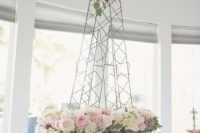 an Eiffel Tower decorated with neutral blooms is a pretty bridal shower decoration or a centerpiece