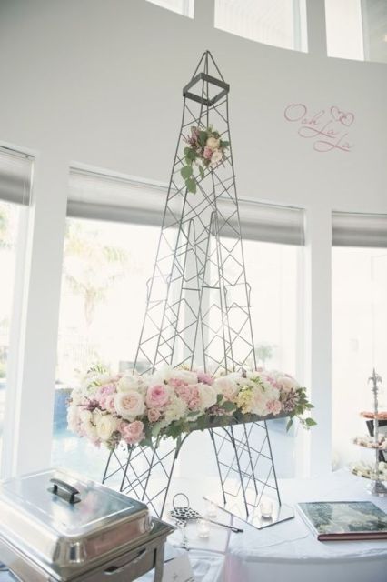 an Eiffel Tower decorated with neutral blooms is a pretty bridal shower decoration or a centerpiece