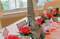 a pretty Parisian bridal shower tablescape with bold blooms, greenery and a mini Eiffel Tower as a centerpiece