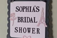 a pink, black and white Parisian-themed bridal shower sign is a cute decor idea that you can easily realize yourself