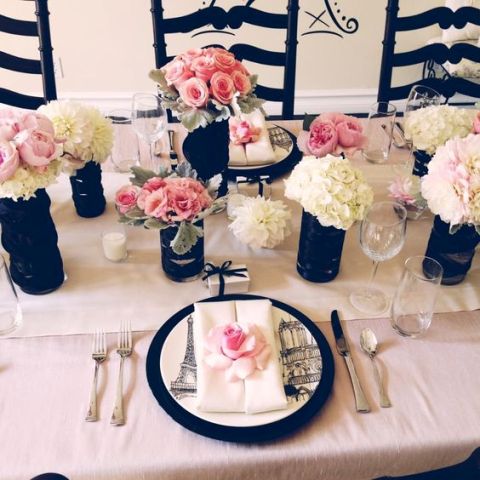 a chic pink, white and black Parisian themed bridal shower tablescape with neutral and blush blooms, black vases and black chargers is a cool idea
