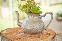 a cute centerpiece of a wood slice, a vintage silver teapot as a vase for succulents and greenery
