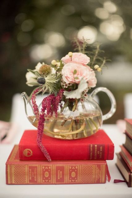 a couple of vintage books with a glass teapot with blooms in burgundy and blush