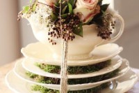 saucepans with moss, a teapot with blush roses and greenery and baker’s twine to secure