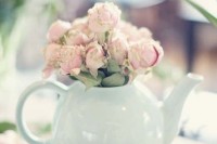 an off-white teapot used as a vase for pink peonies is a cool and relaxed centerpiece idea