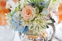 a vintage silver teapot with blue, pink and white blooms, thistles and greenery for a chic centerpiece