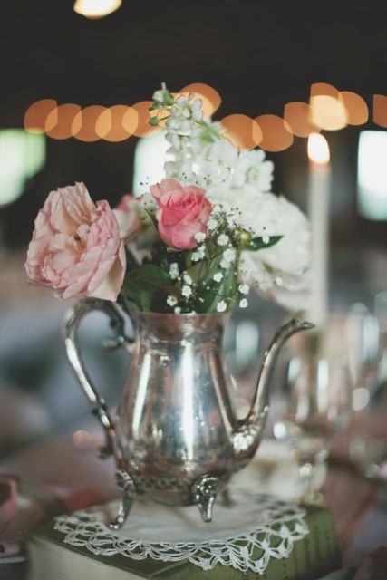 a vintage book with a doily, a silver teapot and white, blush and dusty pink blooms