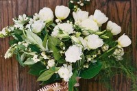 a white wedding bouquet of smaller and larger blooms and much greneery for a textural touch