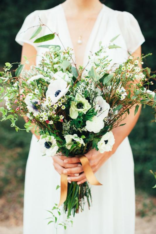 a wedding bouquet with lots of greenery and foliage for a texture and some white anemones