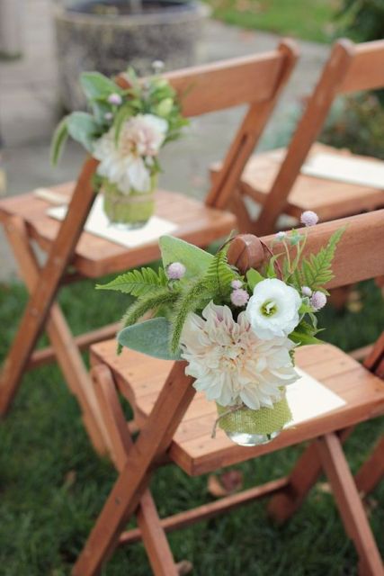 wedding aisle chair decor with a light pink dahlia, a white anemone and some greenery and berries is a creative idea in tender and soft colors