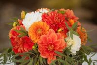 a wooden box with white orange dahlias and greenery is a gorgeous bright wedding centerpiece for a summer or fall wedding